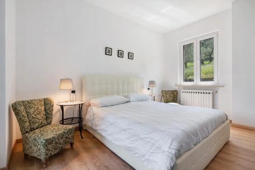 a bedroom with a large bed and a chair at Casa Edda in Brenzone sul Garda
