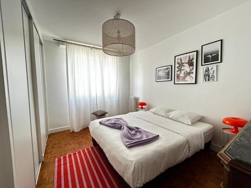 - une chambre avec un lit et une serviette violette dans l'établissement Le Nazarea, cosy en centre-ville, à Limoges