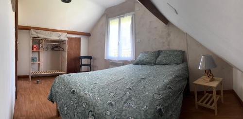a bedroom with a bed with a green comforter and a window at Gîte Bellevue in Ossen