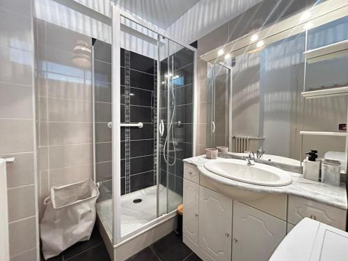 une salle de bain avec une douche en verre et un lavabo dans l'établissement Le Nazarea, cosy en centre-ville, à Limoges