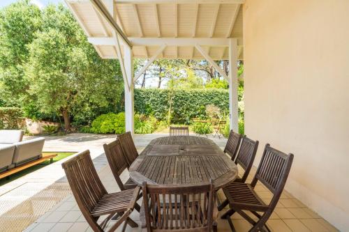 a wooden table and chairs on a patio at Dune Lodge 2- Capbreton Hossegor - in Capbreton