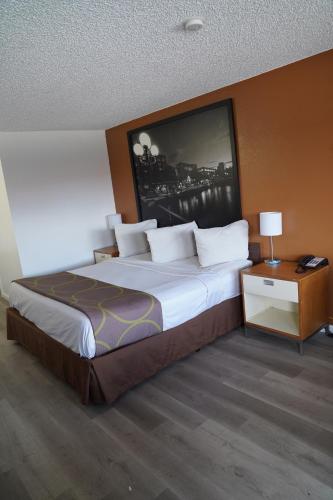 a bedroom with a large bed and a night stand at Super 8 by Wyndham Fernley in Fernley