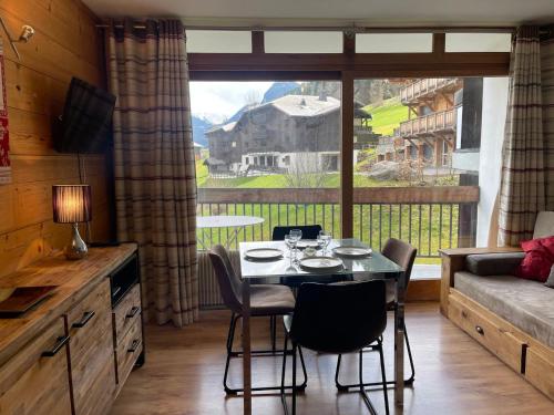 une salle à manger avec une table et une grande fenêtre dans l'établissement Studio skis aux pieds, ensoleillé avec balcon et Wi-Fi à Morzine - FR-1-679-5, à Morzine