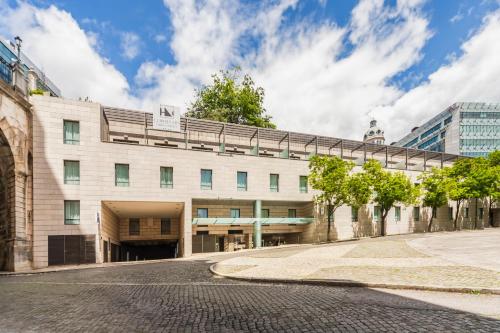 a building with a bridge over a street at Eurostars Lisboa Parque in Lisbon