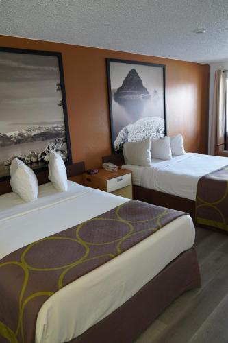 a hotel room with two beds and a painting on the wall at Super 8 by Wyndham Fernley in Fernley
