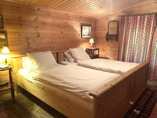 una camera da letto con un letto in una cabina di legno di Jägerwohnung im Forsthaus am Schindelbruch a Stolberg i. Harz
