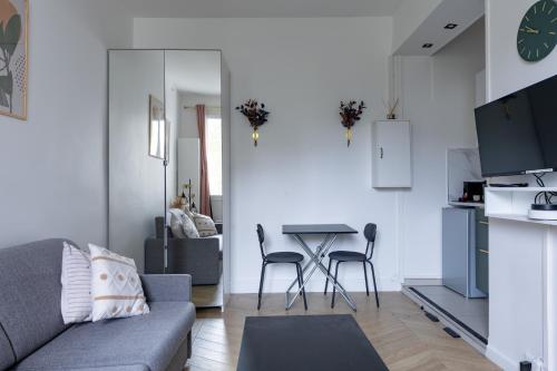 un salon avec un canapé et une table dans l'établissement Romantic 3 Stars - Studio suite by Canal Saint-Martin, à Paris