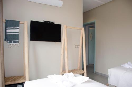 a room with two beds and a flat screen tv on a wall at harmony surf lodge in Taghazout