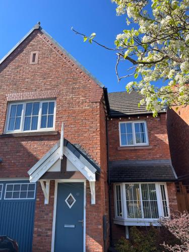 a brick house with a blue door at Cosy Hideout in Timperley