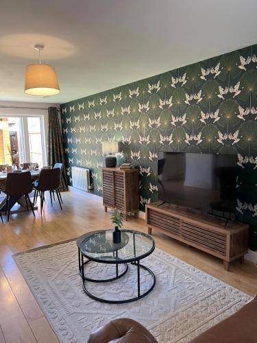 a living room with a flat screen tv and a table at Cosy Hideout in Timperley