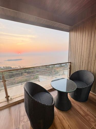 a room with a table and chairs and a large window at NIRAKI VILLA by Seascapes in Harnai