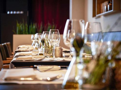 a long table with wine glasses on it at C-Hotels Westwing - ex Mercure in Roeselare
