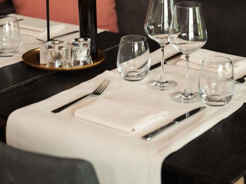 a table with wine glasses and a white napkin at C-Hotels Westwing - ex Mercure in Roeselare
