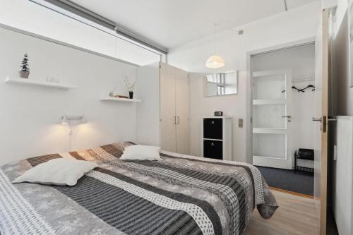 ein Schlafzimmer mit einem großen Bett und einem Fenster in der Unterkunft Feriehus 1122 in Ringkøbing
