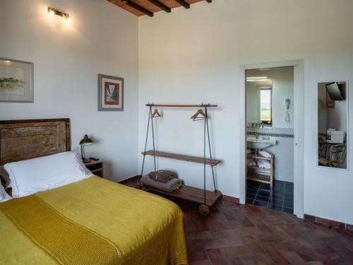 a bedroom with a bed and a bathroom with a sink at Rooms and Wine al Castello in Monteriggioni