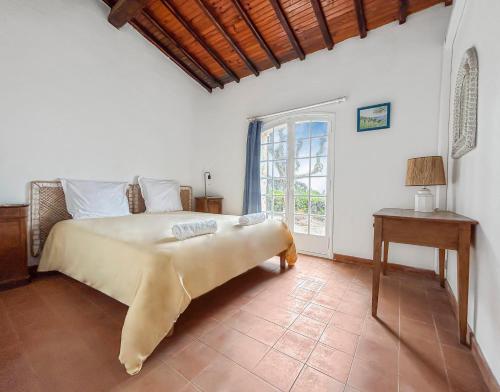 une chambre avec un lit, une table et une fenêtre dans l'établissement Détente provençale avec vue mer, à Sainte-Maxime