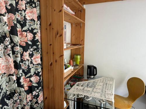 a room with a table and a chair with a wallpaper at Marijke's guestroom in Amsterdam