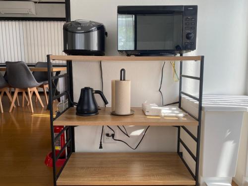 a microwave oven sitting on top of a shelf at 改装済み最大9名まで快適空間 プロジェクター付き1棟貸しの宿 こふみ in Fujikawaguchiko