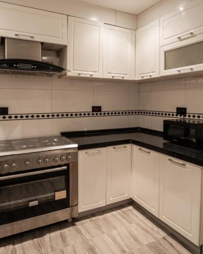 a kitchen with white cabinets and a stove top oven at George Residence SDA Court, Banana Island, Ikoyi in Lagos