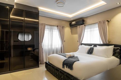 a bedroom with a large white bed and windows at George Residence SDA Court, Banana Island, Ikoyi in Lagos