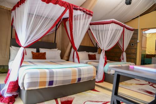 two beds in a room with mosquito nets at Oldarpoi Wageni Camps in Keekorok