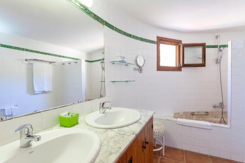 a white bathroom with two sinks and a shower at Cortijo El Sotillo in San José