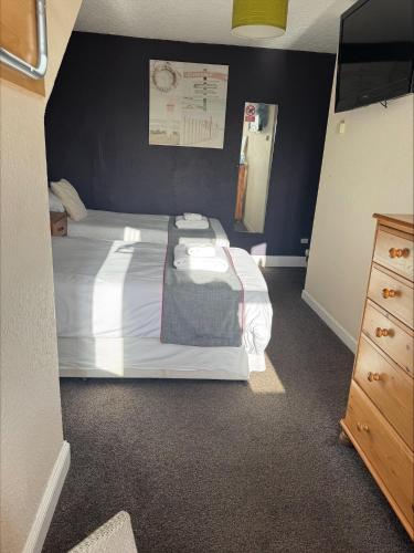 a bedroom with a large bed with a black wall at The Hillside Hotel & Restaurant in Hillside