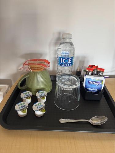 a tray with a bottle of water and a green blender at The Hillside Hotel & Restaurant in Hillside