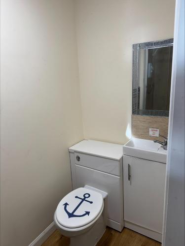 a bathroom with a white toilet and a sink at The Hillside Hotel & Restaurant in Hillside