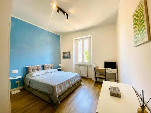 una camera da letto con una parete blu, un letto e una scrivania di Domus 14 a Roma