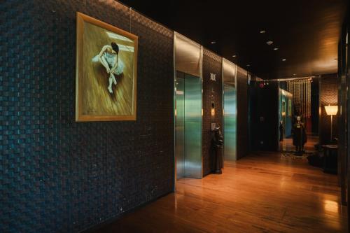 a hallway with a painting of a woman on the wall at TUI BLUE Maduzi Hotel Bangkok in Bangkok