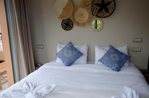a bed with blue and white pillows on it at harmony surf lodge in Taghazout