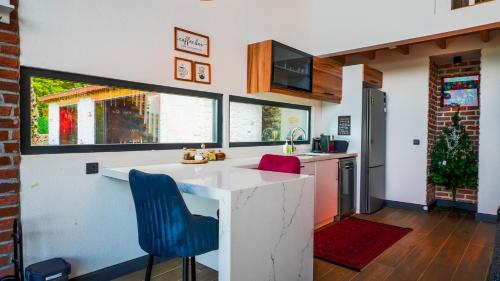 a kitchen with a white counter and blue chairs at Grand Paradise Resort Sapanca in Sapanca