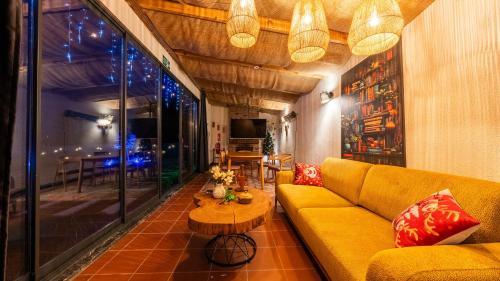 a living room with a yellow couch and a table at Grand Paradise Resort Sapanca in Sapanca