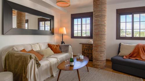 a living room with a white couch and a table at Casa Pegelow in Frigiliana