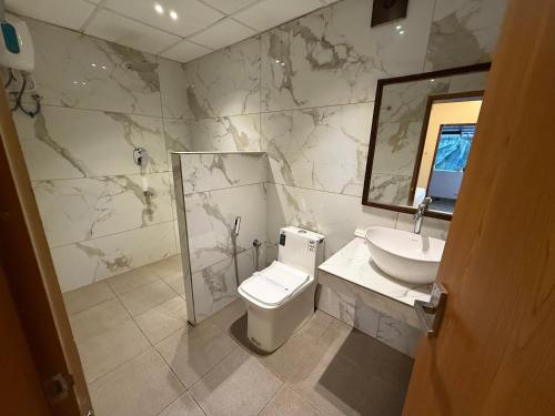 a bathroom with a sink and a toilet and a mirror at Santa Maria - A Premium Boutique Homestay by the Sea I Trivandrum Airport 1mile in Trivandrum