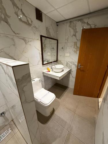 a bathroom with a toilet and a sink and a mirror at Santa Maria - A Premium Boutique Homestay by the Sea I Trivandrum Airport 1mile in Trivandrum
