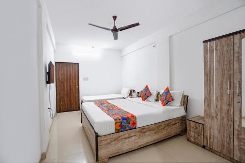 a bedroom with a bed and a wooden door at FabHotel Relax - opp Hotel Leela in Gandhinagar