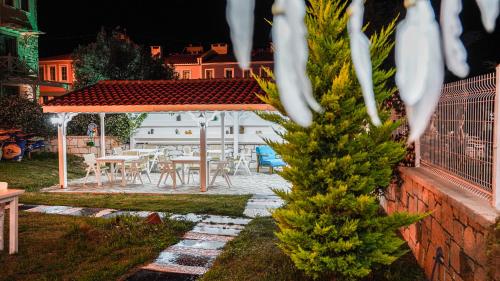 a patio with a table and chairs in a yard at Limonata Bozcaada ex Vina Garden in Bozcaada