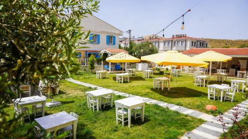 a group of tables and chairs with umbrellas at Limonata Bozcaada ex Vina Garden in Bozcaada