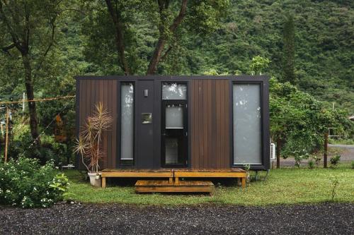 ein kleines Haus mit einer Bank in einem Hof in der Unterkunft Mountain Silhouette Cottage 2 by Tiny Away in Jingmei