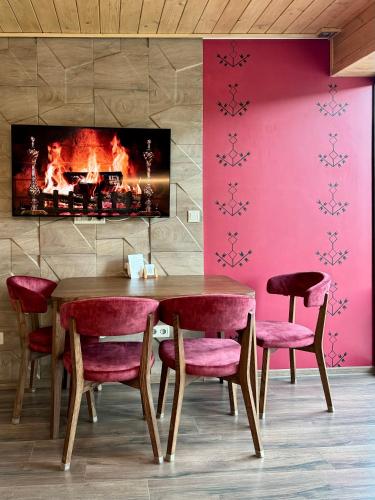 a dining room with a table and chairs and a fireplace at Mirest - котеджі в горах із чаном-джакузі in Slavske