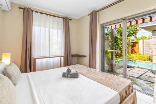 a bedroom with a bed and a large window at Tropical Villa - 3 Bedrooms in the heart of Grand-Baie in Grand Baie