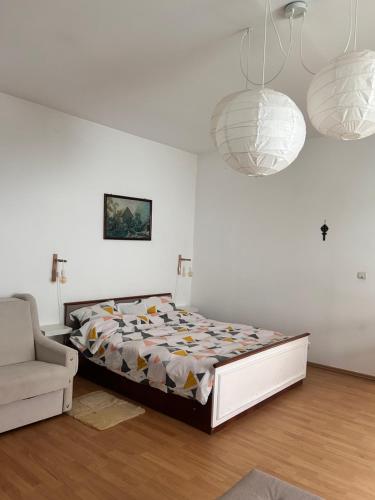a bedroom with a bed and a couch and chandeliers at Elisaveta's Retreat. Come to feel the tranquility! in Râşnov