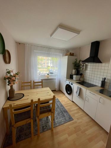 a kitchen with a wooden table and a dining room at 3 kambarių butas pirmame aukšte in Mažeikiai