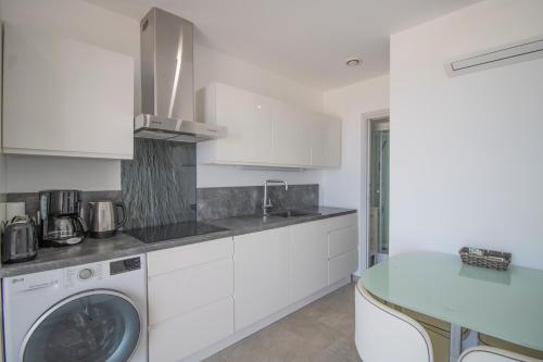 a kitchen with a washing machine and a sink at Sublime Appart Neuf in Albitreccia