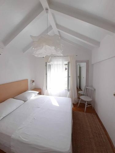 a bedroom with a large white bed and a window at Casa Carlena in Supetar