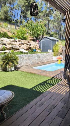 une cour arrière avec une piscine et une terrasse en bois dans l'établissement Jolie villa paisible, à Montferrier-sur-Lez