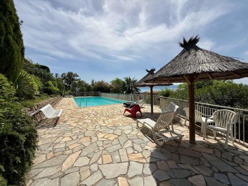 une terrasse avec des chaises et un parasol ainsi qu'une piscine dans l'établissement B084-Confort et serenite piscine et stationnement, à Cannes
