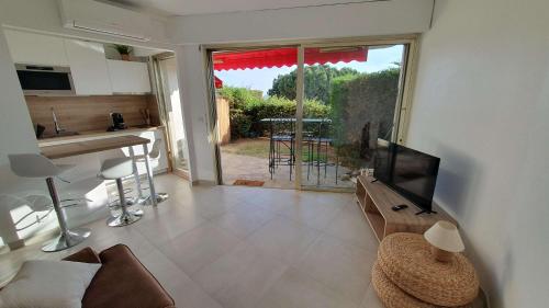 Il comprend un salon avec une télévision à écran plat et une cuisine. dans l'établissement B084-Confort et serenite piscine et stationnement, à Cannes